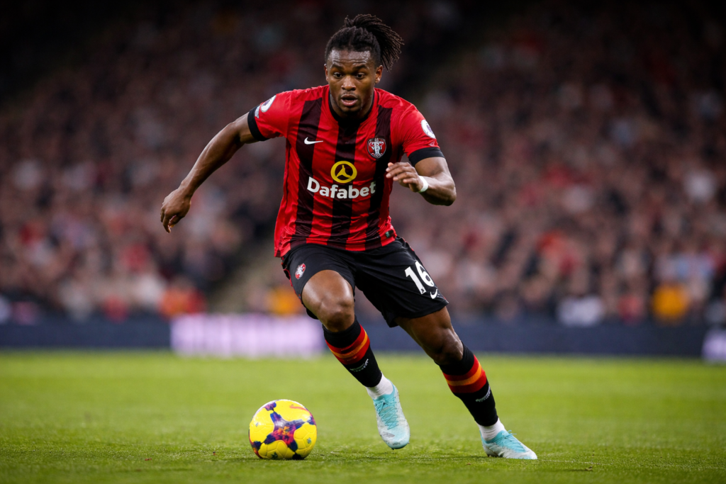 Antoine Semenyo dribbles the ball for Bournemouth during a Premier League match, sprinting forward on the pitch with a blurred crowd behind