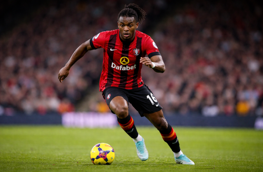Antoine Semenyo dribbles the ball for Bournemouth during a Premier League match, sprinting forward on the pitch with a blurred crowd behind